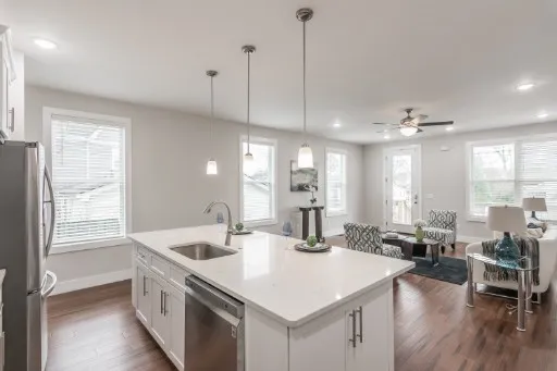a kitchen with counter top space sink stove and wooden floor