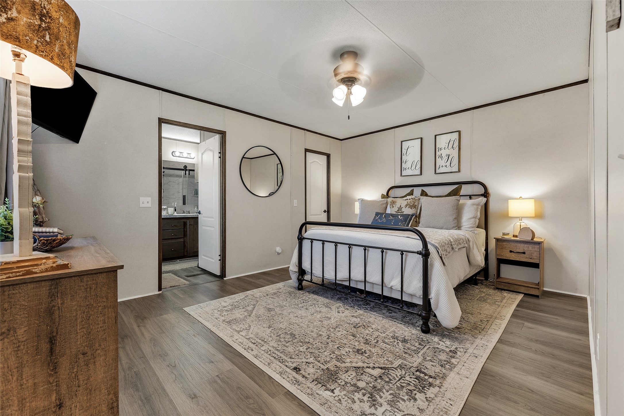 3133 Henderson Road Navasota, TX 77868 - Photo 19 of 26 a bedroom with a bed a flat screen tv and a chandelier