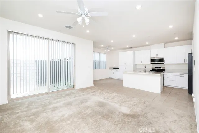 a view of kitchen with kitchen island and stainless steel appliances