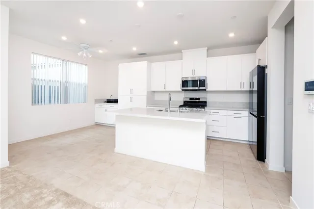 a kitchen with kitchen island white cabinets and refrigerator