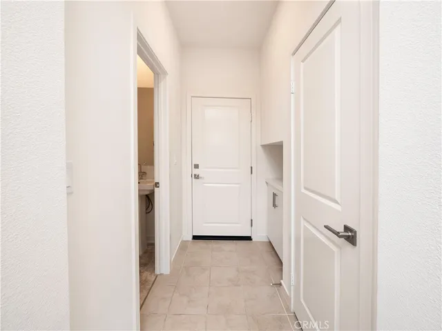 a view of a hallway with closet and a bathroom