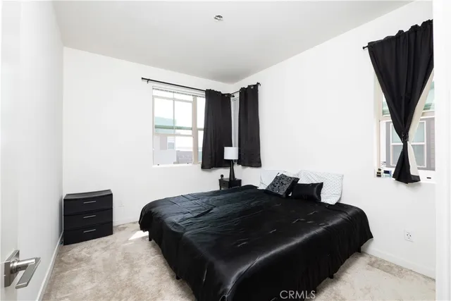 a bedroom with a bed and dresser with mirror