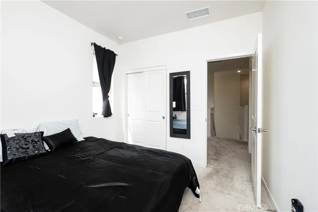 a bedroom with a bed and a large mirror