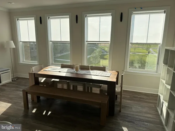 an empty room with wooden floor fireplace and windows