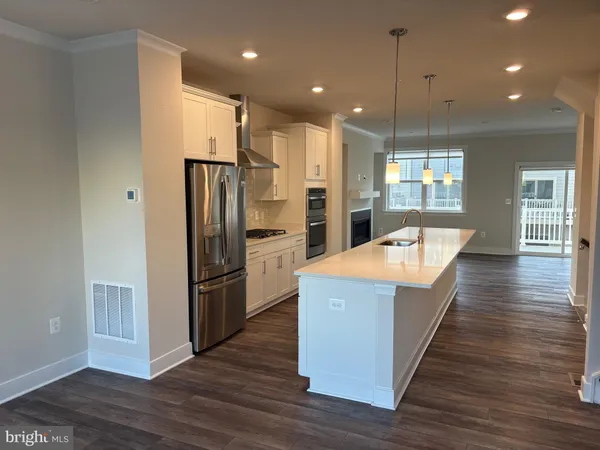 an empty room with wooden floor a fireplace and windows