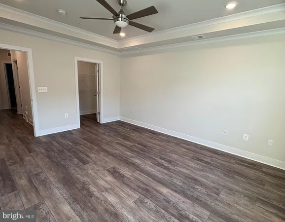 a view of an empty room with window and chandelier fan