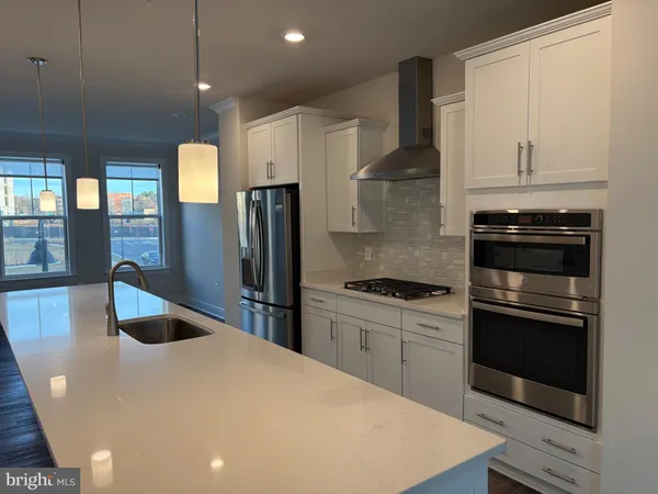 a view of an empty room with wooden floor and window