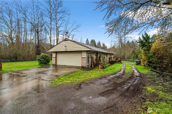 a view of a house with a yard and large tree