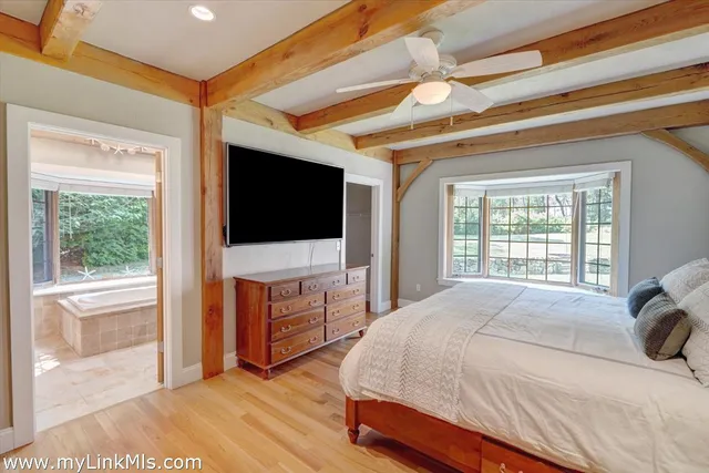 a bedroom with a bed and a flat tv screen on dresser