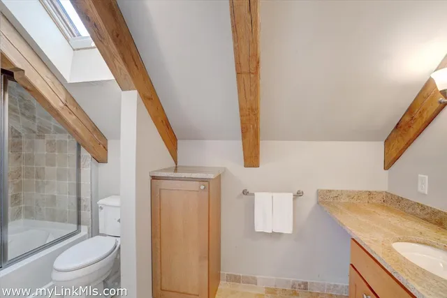a bathroom with a granite countertop sink toilet and shower