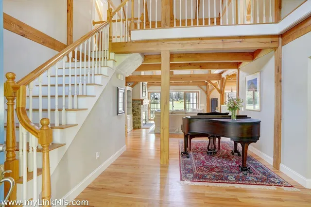 a view of a living room with wooden floor and a rug