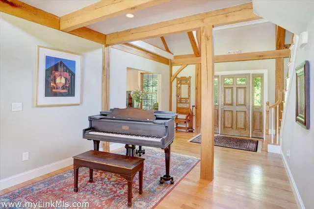 a living room with furniture a piano and a potted plant