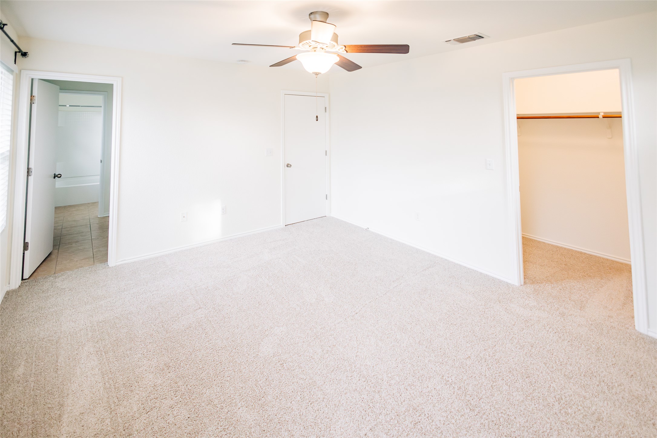 2905 Acopio Bend Austin, TX 78745 - Photo 14 of 29 Unfurnished bedroom featuring light carpet, a spacious closet, ensuite bath, and ceiling fan