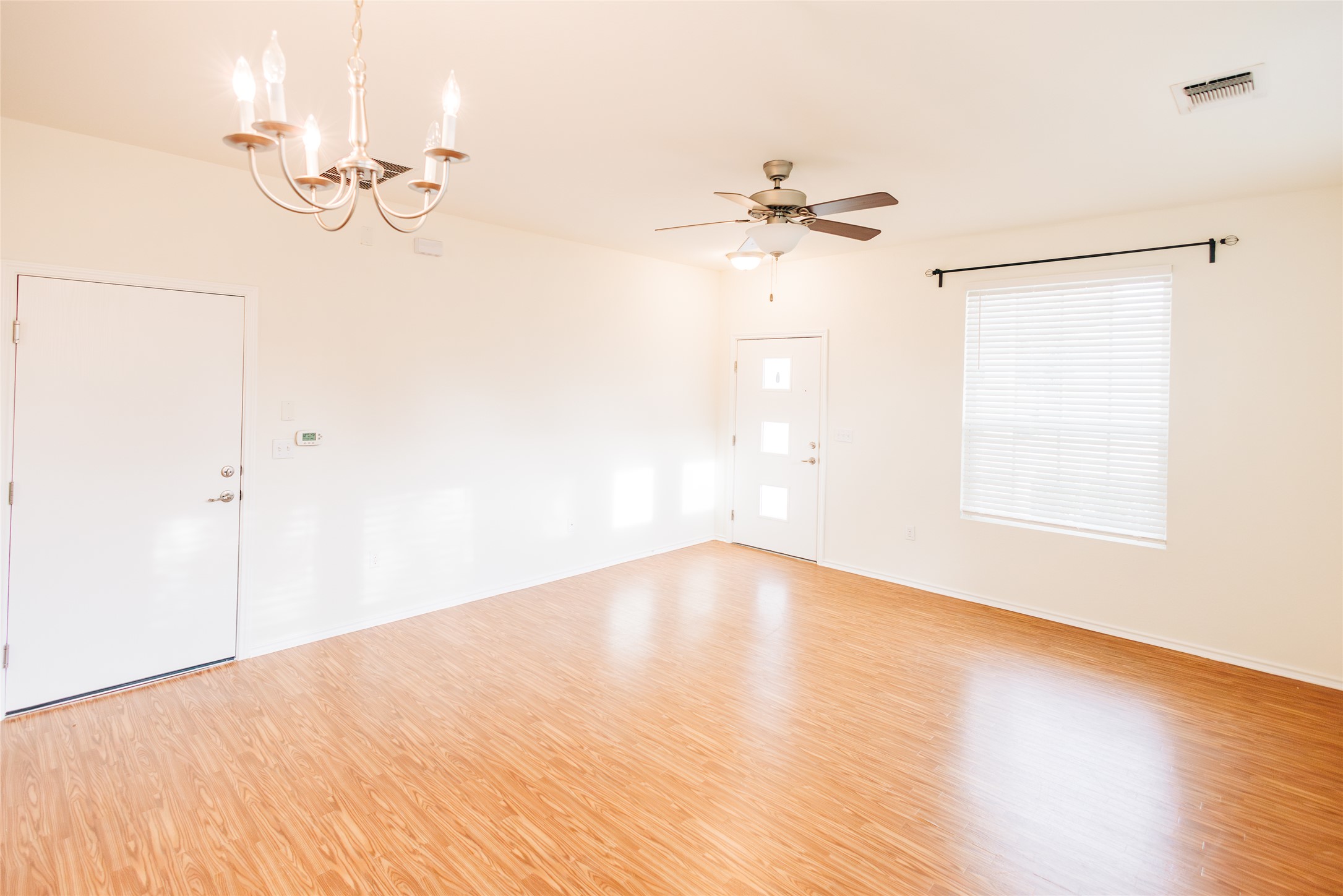 2905 Acopio Bend Austin, TX 78745 - Photo 5 of 29 Empty room featuring a chandelier, light wood-type flooring, and ceiling fan
