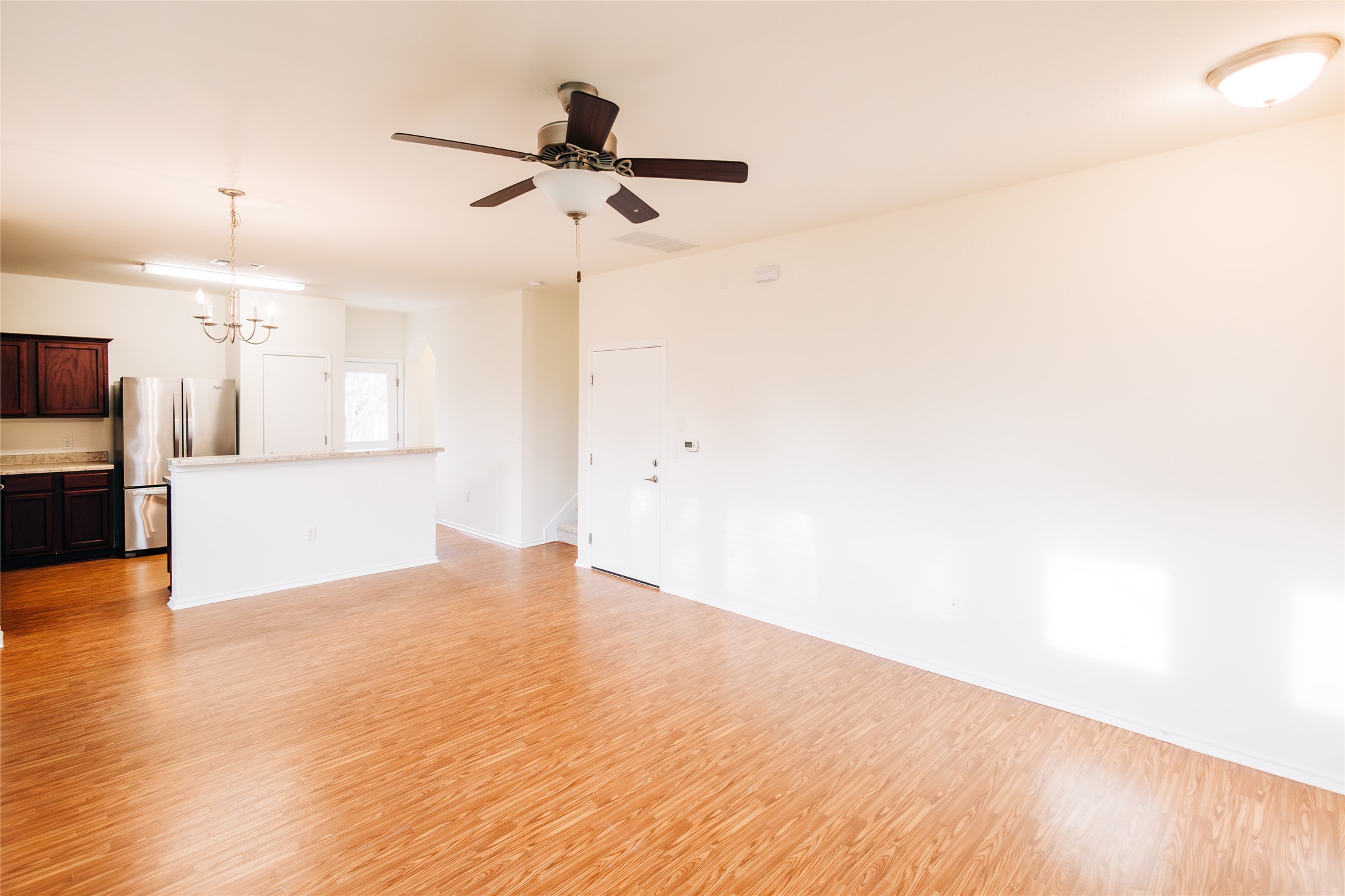 2905 Acopio Bend Austin, TX 78745 - Photo 6 of 29 Unfurnished living room with a chandelier, light wood-style flooring, and a ceiling fan