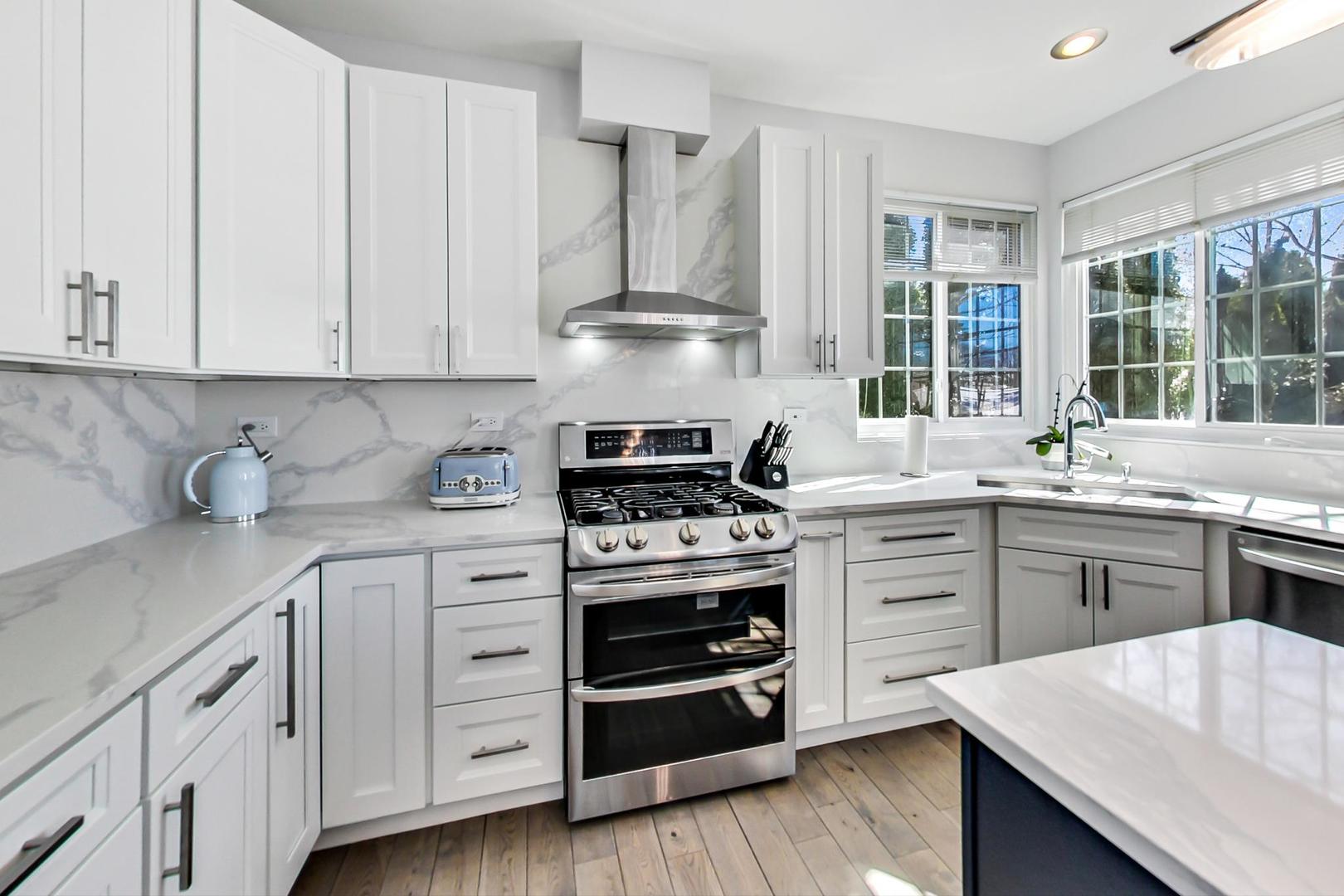 7311 Dada Drive Gurnee, IL 60031 - Photo 10 of 51 a kitchen with cabinets wooden floor and stainless steel appliances