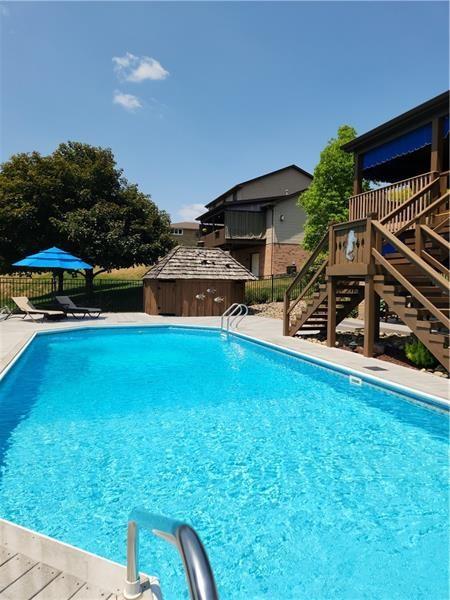 132 Ridge Drive Apollo, PA 15613 - Photo 34 of 37 a view of a swimming pool with lawn chairs under an umbrella