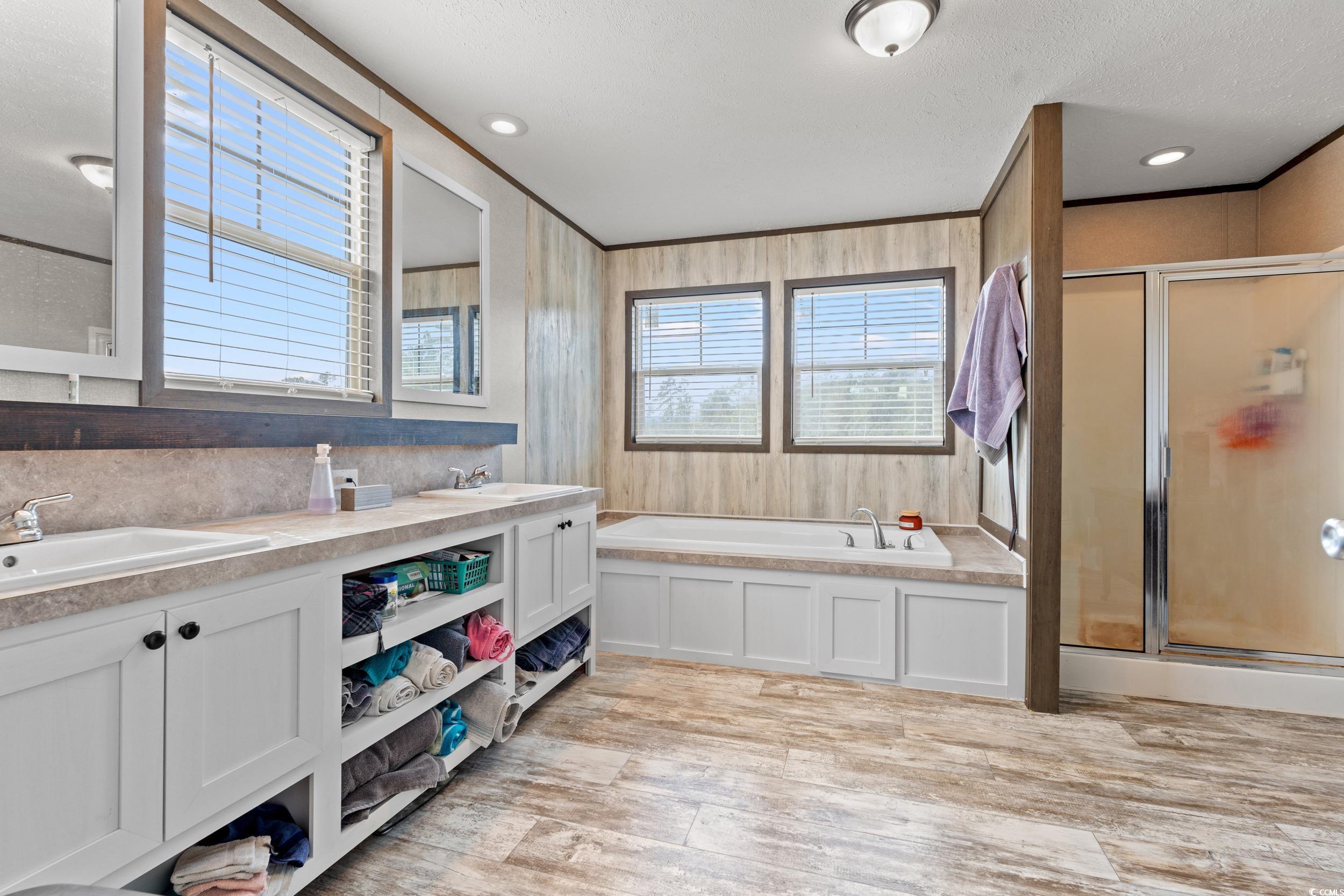 1217 Poplar Creek Road Lake View, SC 29563 - Photo 16 of 38 Full bathroom featuring a shower stall, a bath, double vanity, light wood finished floors, and crown molding