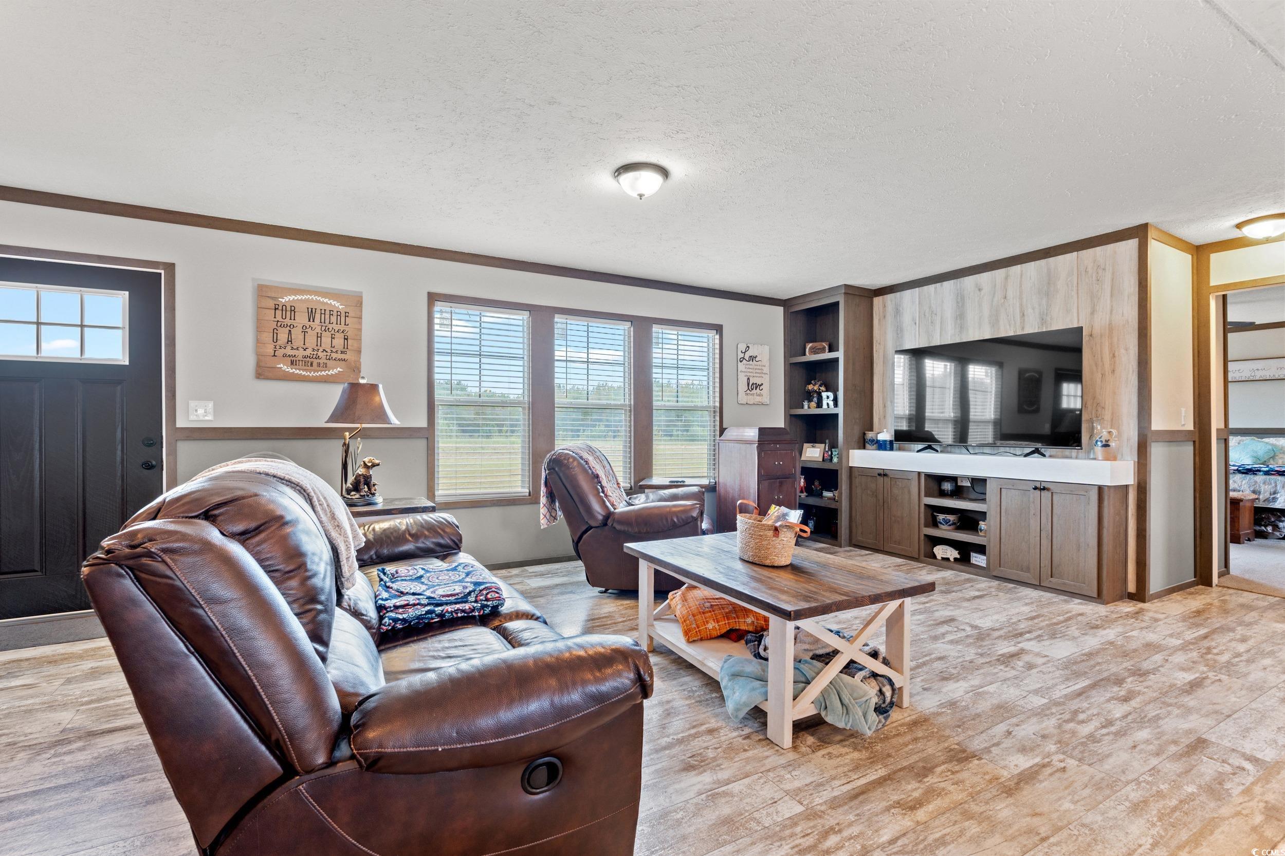 1217 Poplar Creek Road Lake View, SC 29563 - Photo 2 of 38 Living room with a textured ceiling, ornamental molding, and light wood-type flooring