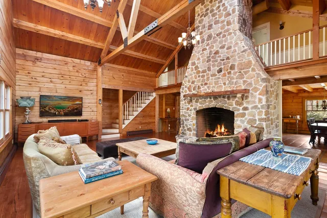 a living room with furniture a fireplace and a large window