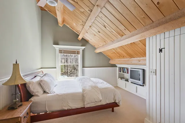 a bedroom with a large bed and a window