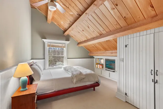 a bedroom with a bed and a lamp on the dresser