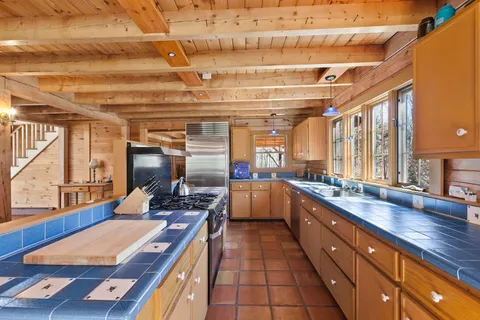 a kitchen with stainless steel appliances kitchen island granite countertop a sink and wooden cabinets