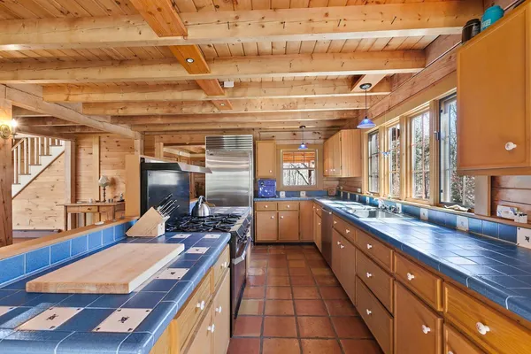 a kitchen with stainless steel appliances kitchen island granite countertop a sink and wooden cabinets