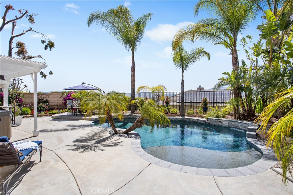 33426 Fox Road Temecula, CA 92592 - Photo 1 of 1 a view of a swimming pool with a lounge chair and palm trees