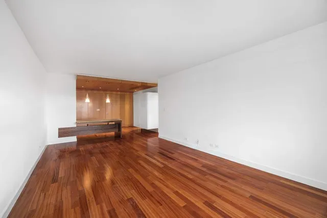 a view of an empty room and wooden floor