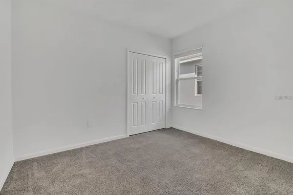 a view of a small space with wooden floor and a window