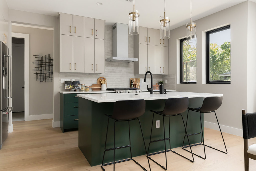 1401 East 3rd Street, Unit 1 Austin, TX 78702 - Photo 11 of 40 Kitchen featuring green cabinetry, an island with sink, decorative backsplash, pendant lighting, and wall chimney exhaust hood
