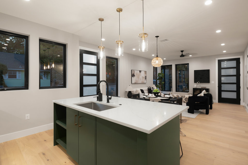1401 East 3rd Street, Unit 1 Austin, TX 78702 - Photo 31 of 40 Kitchen featuring light wood finished floors, green cabinetry, a ceiling fan, an island with sink, and hanging light fixtures