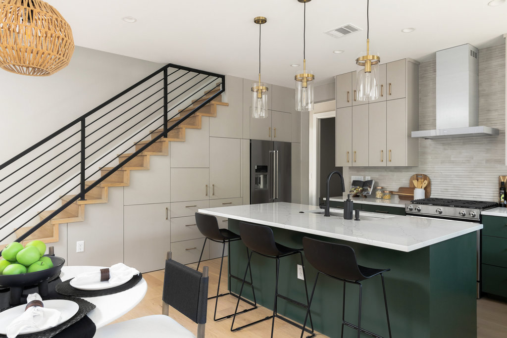 1401 East 3rd Street, Unit 1 Austin, TX 78702 - Photo 37 of 40 Kitchen with green cabinetry, a center island with sink, high end fridge, wall chimney exhaust hood, and hanging light fixtures