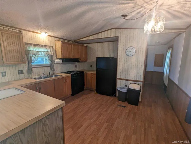 a kitchen with stainless steel appliances a sink cabinets and wooden floor