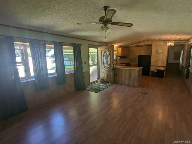 a view of a livingroom with furniture wooden floor and windows