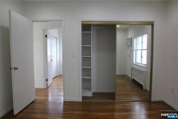 an empty room with wooden floor and closet