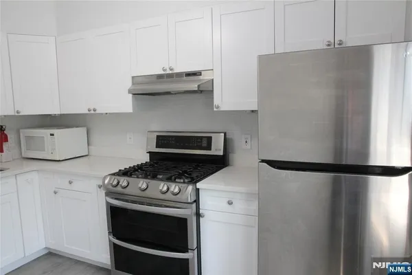 a kitchen with stainless steel appliances a refrigerator stove and microwave