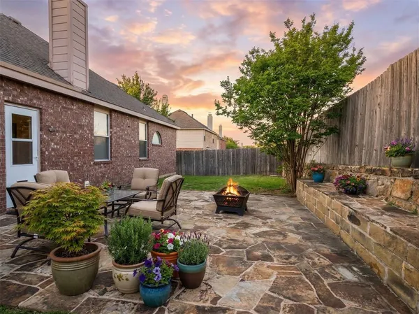 a view of a backyard with table and chairs and potted plants