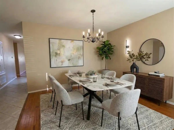 a dining room with furniture a potted plant and wooden floor