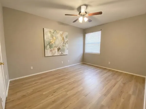 an empty room with wooden floor and window