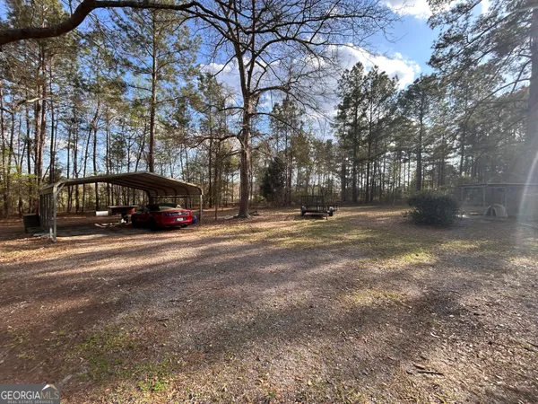 a view of a house with a big yard and large trees