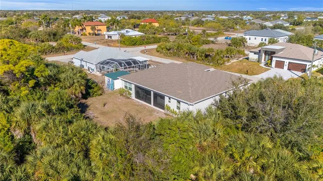 an aerial view of residential houses with outdoor space and trees