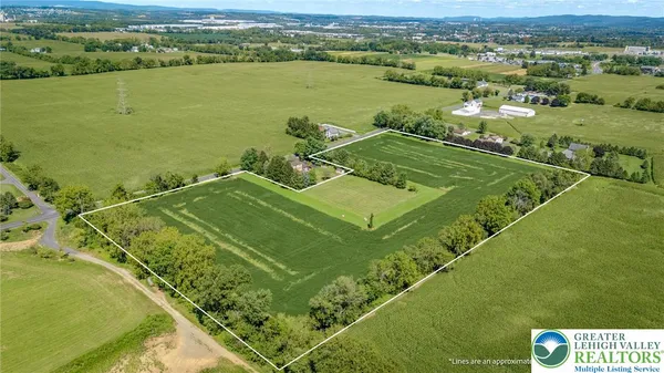 an aerial view of a residential houses with outdoor space and trees