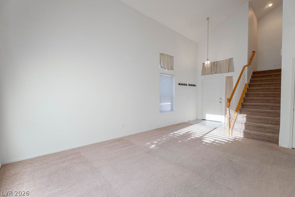 8379 Rockefeller Street Las Vegas, NV 89123 - Photo 4 of 36 High ceilings and soft carpet define this welcoming entryway with an adjacent staircase.