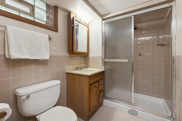 a bathroom with a granite countertop toilet sink and shower