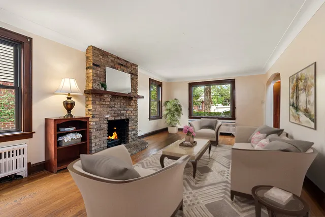 a living room with furniture a fireplace and a large window