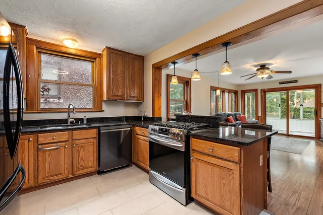 a kitchen with stainless steel appliances granite countertop stove a sink dishwasher and a refrigerator