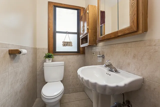 a bathroom with a sink a toilet and mirror
