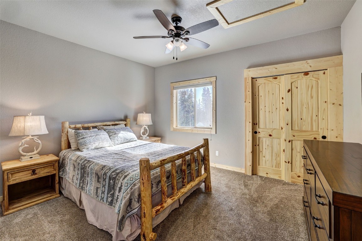 207 Pine Cone Way Fairplay, CO 80440 - Photo 14 of 45 a bedroom with a bed and a chandelier